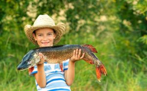 Boy holds big pike he just caught