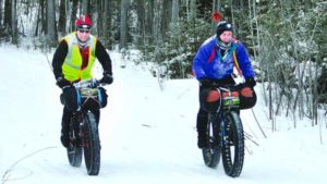 ARROWHEAD0125c2 -- Duluth Todd McFadden (left) and an unidentified competitor ride side by side during the 2012 Arrowhead 135 ultramarathon. Todd McFadden photo